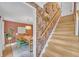 View of a charming dining room from the hallway with unique staircase and patterned wallpaper at 201 Tweed Ct, Sugar Hill, GA 30518