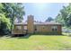 The backyard boasts a well-maintained lawn and a wood deck, complemented by mature trees and partial fencing at 9119 Woodgreen Way, Jonesboro, GA 30238