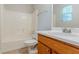 Bright bathroom featuring a shower and tub combo, light tile flooring, and a single sink vanity with wood cabinets at 9119 Woodgreen Way, Jonesboro, GA 30238