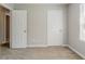 A simple bedroom featuring two doors, carpet, and neutral colored walls at 9119 Woodgreen Way, Jonesboro, GA 30238