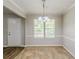 Bright dining room featuring modern light fixture, large window, carpet, and wood-look flooring near the entry door at 9119 Woodgreen Way, Jonesboro, GA 30238