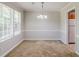 Dining room featuring neutral walls, trim, and carpet with a modern chandelier at 9119 Woodgreen Way, Jonesboro, GA 30238