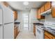 This kitchen features wooden cabinets, white appliances, and views to the garage area at 9119 Woodgreen Way, Jonesboro, GA 30238