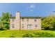 View of the back of the house with a grassy backyard surrounded by mature trees at 9542 Canvasback Ct, Jonesboro, GA 30238