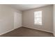Bedroom featuring neutral walls, plush carpeting, a window, and a closet at 9542 Canvasback Ct, Jonesboro, GA 30238