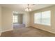 Carpeted dining room with chandelier, window and view into adjacent carpeted living area at 9542 Canvasback Ct, Jonesboro, GA 30238