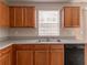 Efficient kitchen layout with wooden cabinets, stainless steel sink, and modern dishwasher at 9542 Canvasback Ct, Jonesboro, GA 30238