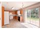 Bright kitchen features wood cabinets, white appliances, tile floor, and sliding glass door to backyard at 9542 Canvasback Ct, Jonesboro, GA 30238