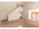 Open living room view of kitchen with white appliances, stairs, and neutral decor at 9542 Canvasback Ct, Jonesboro, GA 30238