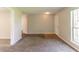 Living room with neutral colors, new carpeting, a window and access to other rooms at 9542 Canvasback Ct, Jonesboro, GA 30238
