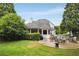 Expansive backyard featuring a patio with outdoor furniture, lush lawn, and mature trees at 1023 Spruce Creek Ln, Lawrenceville, GA 30045