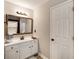 Bathroom featuring a single vanity with white cabinets and decorative mirror at 1023 Spruce Creek Ln, Lawrenceville, GA 30045