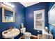 Cozy bathroom with dark blue walls, white fixtures, and a modern vanity at 1023 Spruce Creek Ln, Lawrenceville, GA 30045