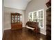 Well lit formal living room with a piano and display case in front of a large window at 1023 Spruce Creek Ln, Lawrenceville, GA 30045