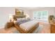 Serene main bedroom featuring hardwood floors, a comfortable bed, and natural light from the large window at 1305 Kelly Nelson Dr, Lawrenceville, GA 30043
