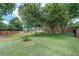A grassy backyard surrounded by a wooden fence and a variety of leafy trees at 3243 Northbrook Dr, Atlanta, GA 30341