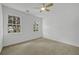 Well-lit bedroom with neutral carpet, ceiling fan, and two windows offering natural light at 3243 Northbrook Dr, Atlanta, GA 30341