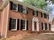 Up-close view of the red brick exterior featuring a red front door and black shutters at 3243 Northbrook Dr, Atlanta, GA 30341