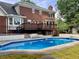 Backyard view featuring a sparkling in-ground pool, deck, and brick patio at 3243 Northbrook Dr, Atlanta, GA 30341