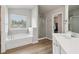 Bathroom featuring a garden tub with window and a glass enclosed shower at 4172 Cedar Commons Way, Conley, GA 30288