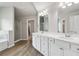 Bright bathroom featuring double vanity, quartz counters, framed mirrors and wood-look floors at 4172 Cedar Commons Way, Conley, GA 30288