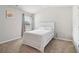 A bright bedroom featuring a light fixture, neutral walls, carpeted floors, and a window at 4172 Cedar Commons Way, Conley, GA 30288
