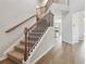 Bright entryway with hardwood floors and staircase featuring wood railings and wrought iron spindles at 4172 Cedar Commons Way, Conley, GA 30288