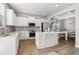 Well-lit kitchen with white cabinets, a center island, stainless appliances, and an adjacent dining area at 4172 Cedar Commons Way, Conley, GA 30288
