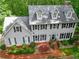 Aerial view of a large two-story home with manicured landscaping and surrounded by lush trees at 120 Majesty Ln, Fayetteville, GA 30215
