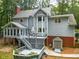 View of the home's backyard featuring a deck, patio, shed, lush landscaping, and mature trees at 120 Majesty Ln, Fayetteville, GA 30215