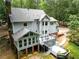 Aerial view of the home's backyard featuring a deck, patio, screened in porch, and lush landscaping at 120 Majesty Ln, Fayetteville, GA 30215
