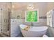 Modern bathroom featuring a soaking tub with a view, walk-in shower, and chandelier lighting at 120 Majesty Ln, Fayetteville, GA 30215