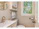 Charming powder room featuring a stained glass window, designer fixtures, and updated vanity at 120 Majesty Ln, Fayetteville, GA 30215