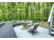 Outdoor deck surrounded by lush trees featuring a firepit and patio furniture at 120 Majesty Ln, Fayetteville, GA 30215