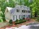 View of home showcasing two-car garage, brick foundation, and mature landscaping in a serene wooded setting at 120 Majesty Ln, Fayetteville, GA 30215