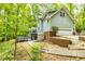 Exterior side view featuring a multi-story home, wooden deck, garage, and lush, mature trees at 120 Majesty Ln, Fayetteville, GA 30215