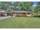 Beautiful single-story home with a lush green lawn, brick and wood accents, and a welcoming pergola entrance at 2468 Dresden Ne Dr, Atlanta, GA 30341