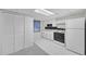 White kitchen featuring modern appliances, cabinets, and a black backsplash at 2468 Dresden Ne Dr, Atlanta, GA 30341
