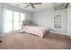 Bright bedroom with a large window, carpeted floor, ceiling fan, and stylish furnishings at 2917 Ashebrooke Ne Dr, Marietta, GA 30068