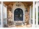 An inviting front entrance featuring a stone archway, a wrought iron double door, and elegant sconce lighting at 2917 Ashebrooke Ne Dr, Marietta, GA 30068