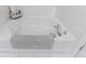 Bright bathtub features a cozy gray bathmat, shiny chrome fixtures, and a classic white tile surround at 3150 Woodwalk Se Dr # 2204, Atlanta, GA 30339