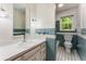This bathroom has stylish light blue tiling, a white sink and vanity and a window that provides natural light at 3541 Castlehill Ct, Tucker, GA 30084
