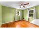 A bedroom painted in a pleasant green color with hardwood floors and two windows for ample natural light at 3541 Castlehill Ct, Tucker, GA 30084