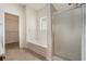 Bathroom featuring a soaking tub with tiled backsplash and a shower with glass doors at 7761 Parkside Dr, Lithia Springs, GA 30122