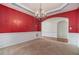 Dining room featuring a hanging light fixture, a red accent wall, and an open doorway to another room at 7761 Parkside Dr, Lithia Springs, GA 30122
