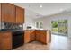 Kitchen featuring wood cabinets, stainless dishwasher, dark countertops and sliding doors to the backyard at 7761 Parkside Dr, Lithia Springs, GA 30122