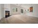 Spacious living room featuring a fireplace, neutral carpet, and a sliding glass door at 7761 Parkside Dr, Lithia Springs, GA 30122