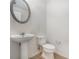 Powder room featuring a pedestal sink, toilet, and decorative mirror at 7761 Parkside Dr, Lithia Springs, GA 30122