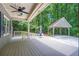 Spacious back deck features a ceiling fan and a covered parking area surrounded by lush greenery at 1940 Country Pl, Cumming, GA 30040
