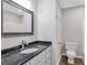 Bathroom featuring a dark granite countertop and a sleek mirror above the vanity at 1940 Country Pl, Cumming, GA 30040